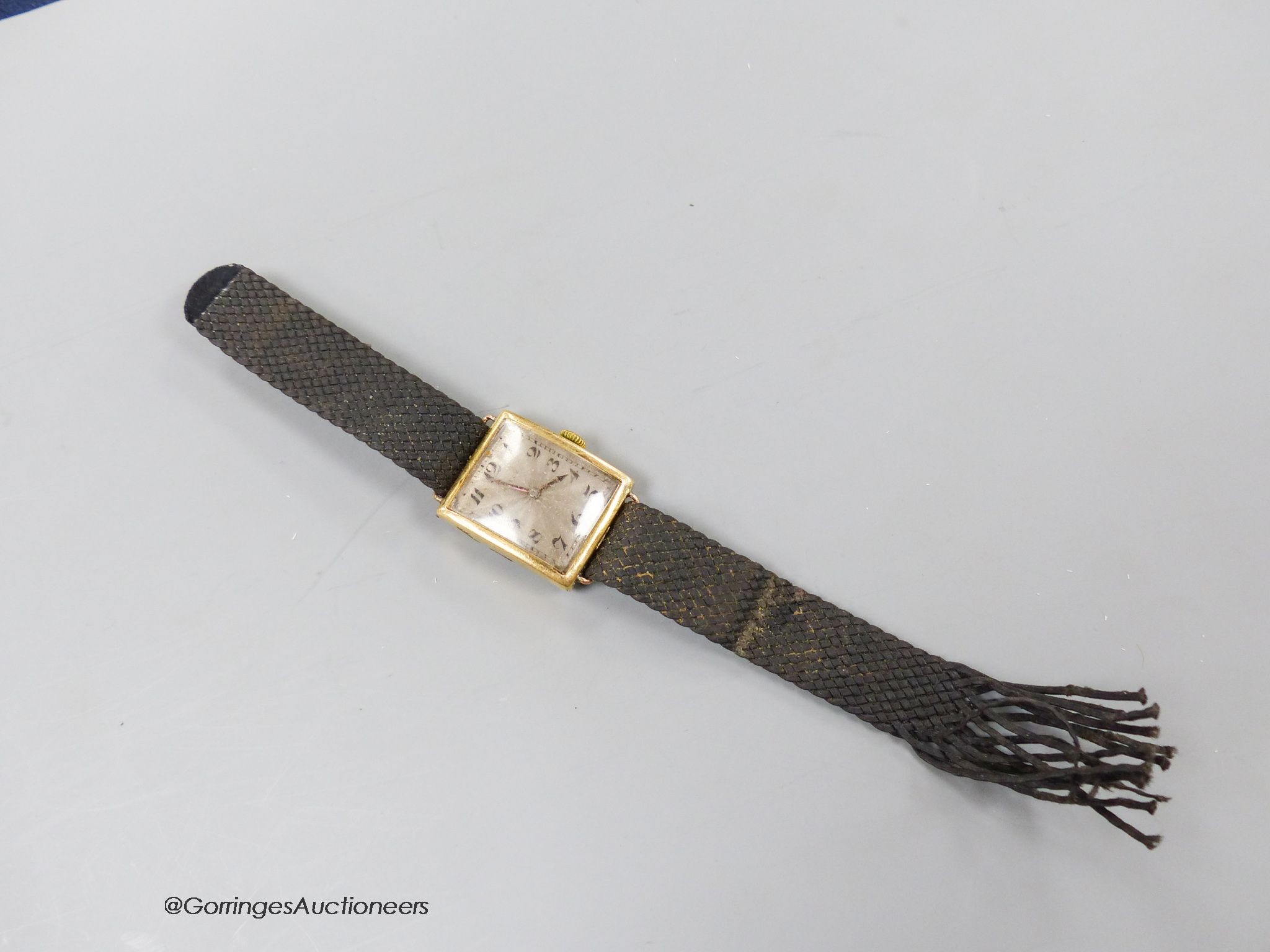 A gentleman's stylish 1920's 18ct gold Rolex manual wind curved case wrist watch, with silvered sunburst Arabic dial, case diameter 25mm, on a damaged associated fabric strap, gross weight 24 grams.